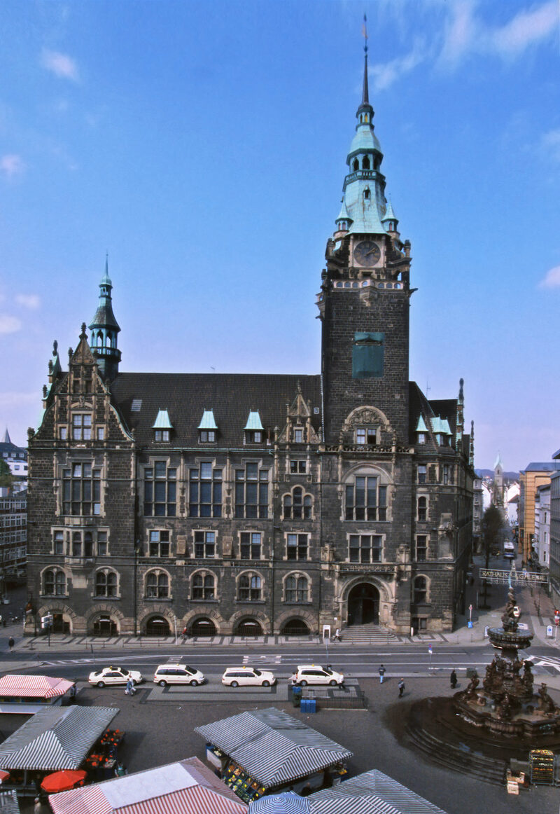 Gesamtansicht des Historischen Rathauses Elberfeld, im Vordergrund der Neumarkt mit Marktständen, blauer Himmel im Hintergrund