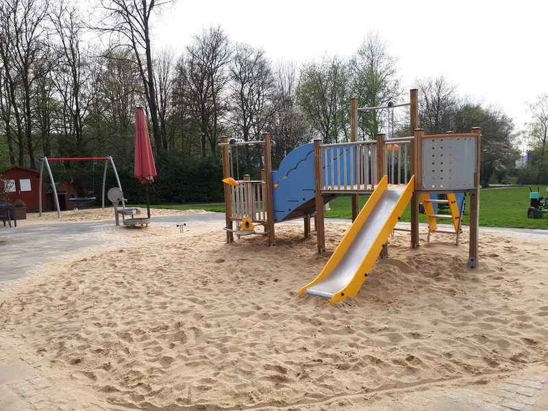 Sanierter Spielplatz an der Wuppertaler Kindernotaufnahme mit Nestschaukel, Klettergerüst mit Rutsche und Wasserspielbereich.