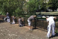 Azubis des Ausbildungsprojektes Ufer streichen das Geländer am Wupperufer am Alten Markt