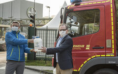 Oberbürgermeister Andreas Mucke nimmt Desinfektionsmittel der Firma Bayer entgegen