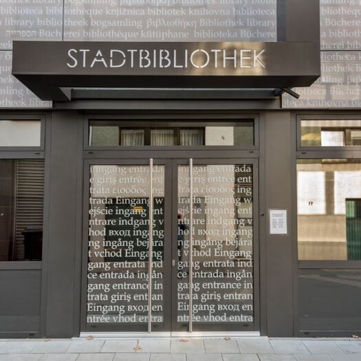 Eingang der Zentralbibliothek mit Schriftzug auf den gläsernen Flächen