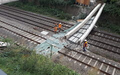 Arbeiter schauen sich die eingestürzten Brückenträger an