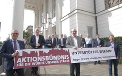 Vertreter der Städte beim Start der Online-Petition in Duisburg halten ein Transparent hoch