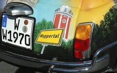 Rückfront eines Autos, auf dem ein Wuppertal-Schild und der Elisenturm zu sehen sind