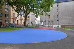 Blaues Basketballfeld, im Hintergrund Fußballfeld