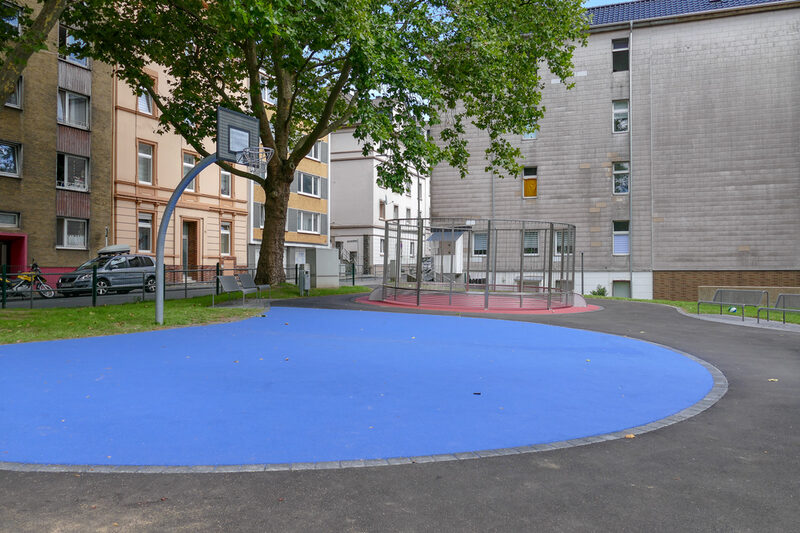 Blaues Basketballfeld, im Hintergrund Fußballfeld