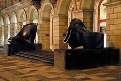 beleuchteter Museumseingang mit zwei Skulpturen von Tony Cragg