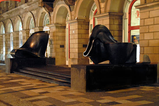 beleuchteter Eingang des Von der Heydt-Museums mit zwei Skulpturen von Tony Cragg