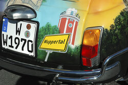 Der Elisenturm und ein Stadtschild sind in einer Fotomontage neben einem Autokennzeichen zu sehen
