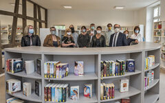 Neue Empfangstheke mit Bücherregal in der Stadtteilbibliothek Cronenberg. Wegen der Corona-Schutzmaßnahmen tragen alle Personen einen Mundschutz.