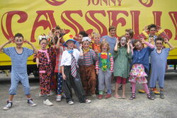 Kostümierte Kinder vor einem Zirkuswagen