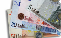 Euroscheine und -münzen vor weißem Hintergrund
