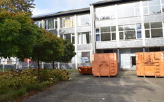 Vor der ehemaligen Justzivollzugsschule stehen orangefarbenen Container