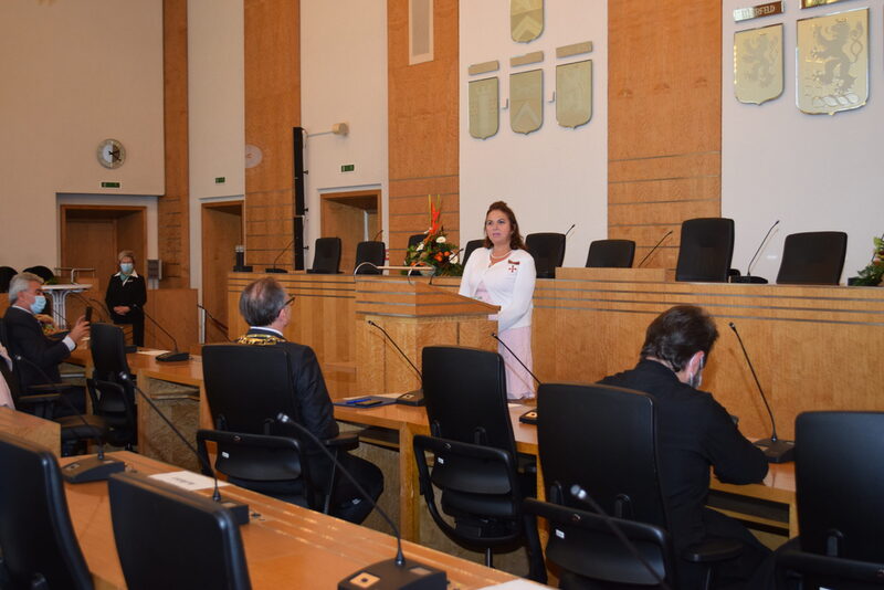 Georgia Manfredi steht am Redepult im Ratssaal, der Oberbürgermeister hört zu.