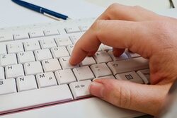 Symbolbild: Hand auf Tastatur
