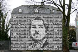 Animation der verhüllten Engels-Fassade mit vielen Einzelportraits und darüber dem großen Portrait von Friedrich Engels