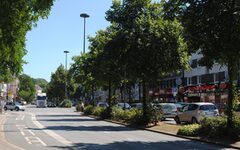 Blick in die B 7 Richtung Oberbarmen: breite Straße mit Bäumen und Geschäften