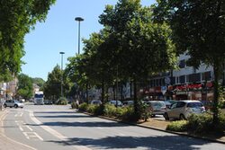 Blick in die B 7 Richtung Oberbarmen: breite Straße mit Bäumen und Geschäften