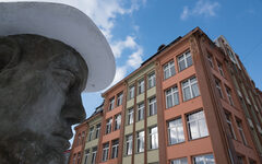 Die Fassade des früheren Art Hotels, im Vordergrund eine große Statue, die Beuys darstellt
