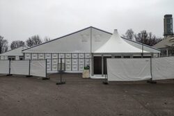 Ein großes weißes Zelt mit weißen Sichtschutzzäunen umgeben