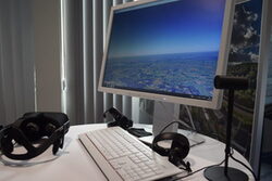 Ein Monitor, eine Tastatur und ein Headset auf einem Tisch