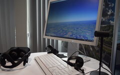 Ein Monitor, eine Tastatur und ein Headset auf einem Tisch
