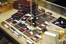 Zur Versteigerung freigegebene Handys liegen unter Glasscheibe