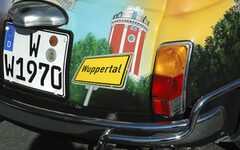 Ein collage zeigt einen Oldtimer mit Wuppertal-Kennzeichen, einen Ortseingangsschild und dem Luisenturm