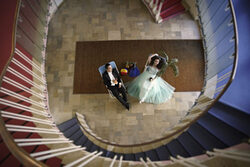 Im Treppenahsus der Oper sieht man von oben eine Frau und einen Mann in Liegestühlen