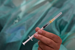 Symbolbild: Hand hält Impfspritze in die Kamera
