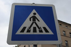 Ein Verkehrsschild zeigt eine Figur, die einen Zebrastreifen überquert