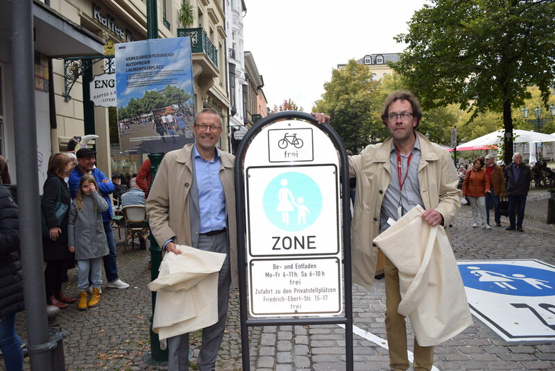 Oberbürgermeister Uwe Schneidewind und Bezirksbürgermeister Thomas King am Schild, das die Friedrich-Ebert-Straße auf Höhe des Laurentiusplatzes autofrei ausweist.