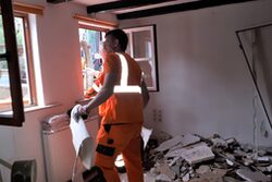 Ein Helfer beim Räumen eines beschädigten Hauses