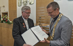 Oberbürgermeister Uwe Schneidewind überreicht Michael Kroemer die Urkunde zum Orden