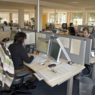 Mitarbeiter sitzen im Servicecenter an Computern