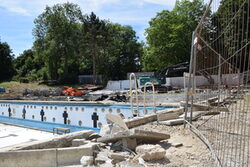 Baustelle im Freibad: Baumaterial und Betonbrocken, im Hintergrund das leere Schwimmbecken