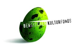 Das Logo des Kulturfonds ist ein schräg durchgeschnittenes grünes Ei mit schwarzen Flecken