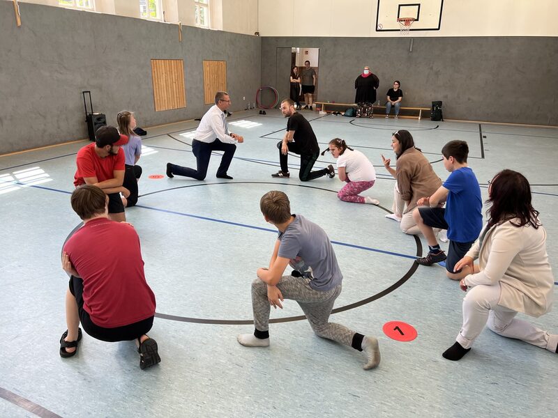 Wuppertals Oberbürgermeister Uwe Schneidewind trainiert Breakdance mit Workshop-Teilnehmern.