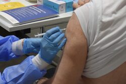 Ein Mensch bekommt eine Corona-Impfung in den Oberarm gespritzt