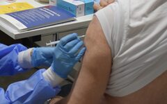 Ein Mensch bekommt eine Corona-Impfung in den Oberarm gespritzt