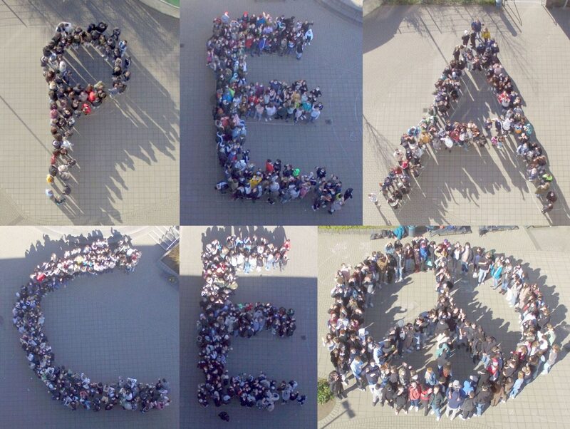 Die Schülerinnen und Schüler haben sich so aufgestellt, dass sie das Wort "Peace" und das Peace-Zeichen bilden