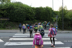 Die Kinder gehen gemeinsam über eine Straße