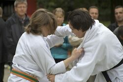 2 Kinder in weißen Judoanzügen treten gegeneinander an