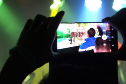 Eine Person nimmt ein Video mit seinem Smartphone auf.