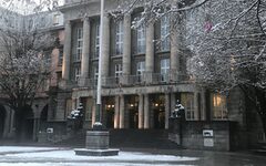 Die Front des Rathauses, davor Schnee auf dem Patz und auf den Bäumen