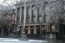 Die Front des Rathauses, davor Schnee auf dem Patz und auf den Bäumen