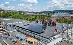 Mitarbeiter des städtischen Gebäudemanagements und der Stadtwerke mit Oberbürgermeister Uwe Schneidewind auf dem Dach des Gymnasiums Sedanstraße
