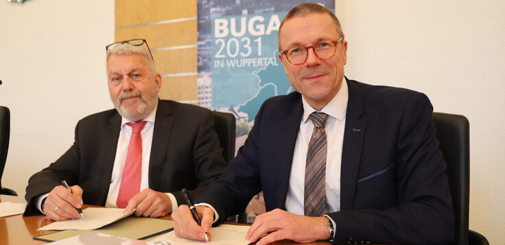 Jochen Sandner von der Deutschen Bundesgartenschaugesellschaft (DBG) und Wuppertals Oberbürgermeister Uwe Schneidewind unterzeichnen den Durchführungsvertrag für die BUGA 2031 in Wuppertal