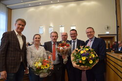 Thorsten Bunte, zweiter von rechts, nimmt Glückwünsche und Blumen von Oberbürgermeister Uwe Schneidewind und Vertreterinnen und Vertretern der Fraktionen entgegen