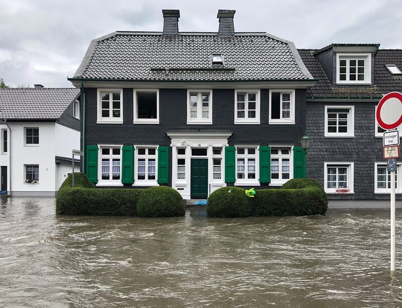 Bergisches Schieferhaus mit den typischen grünen Fensterläden ist vom Hochwasser eingeschlossen